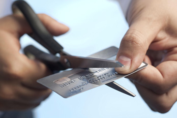 Scissors cutting a credit card to eliminate debt